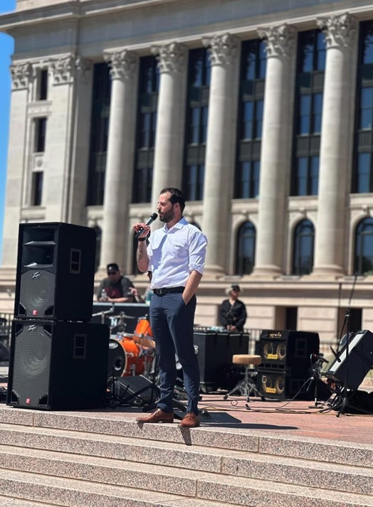 Gabe Woolley speaking at an outdoor event